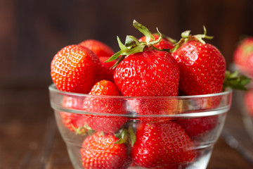 Fresh homemade strawberries in a glass bowl, top view.