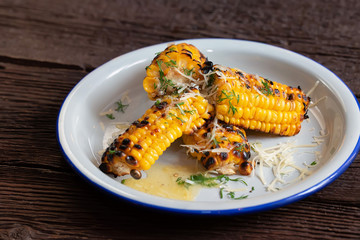 Close up grilled corn on the cob in white plate