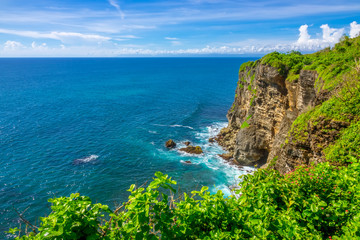 Indonesia. Rocky Coast of a Tropical Island and Sunny Day. Stock photo.