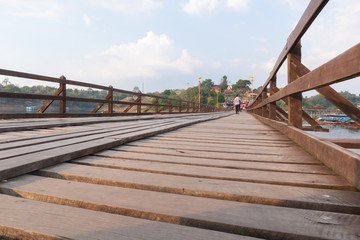 Fototapeta na wymiar Tourists crowded on Wooden Mon Bridge at kanchanaburi, Thailand