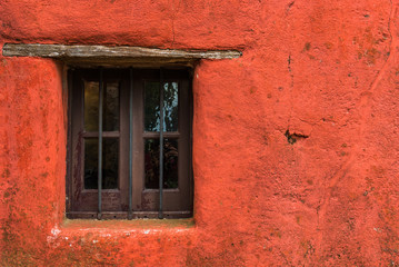 Fototapeta na wymiar Colorful red vintage retro window and wall of an old house building