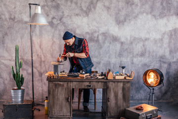 young jeweler replacing stones in rings, full length photo. copy space.