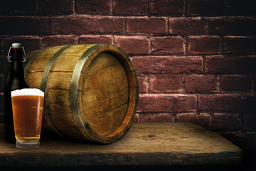 Wooden barrel and glass of beer on a old oak table of wood.