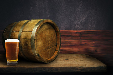 Wooden barrel and glass of beer on a old oak table of wood.