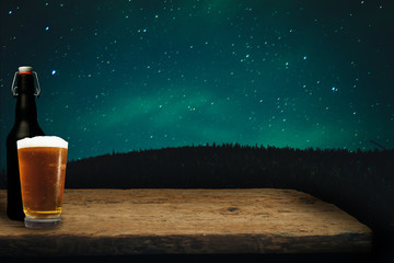 Glass of beer on a old oak table and background