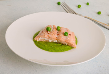 Baked salmon steak with sesame seeds and served with mashed green peas