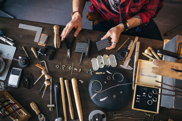 man grinding the pliers inndoors . top view photo