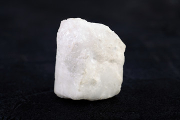 Raw Blue Calcite from Slyudyanka, Baikal, Russia on black cement background.