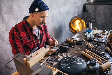 young man cleaning the jewelry at workshop. close up photo. copy space
