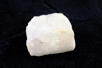 Raw Blue Calcite from Slyudyanka, Baikal, Russia on black cement background.