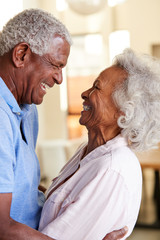 Profile Shot Loving Senior Couple Hugging At Home Together