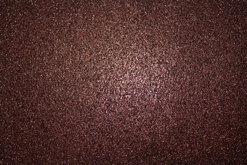 rötlicher glitzernder Hintergrund der in der Mitte heller ist