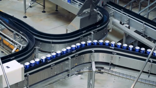 Canned beer on a brewery conveyor, close up.