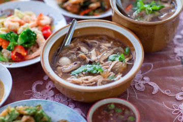 scoop Chinese style soup; or braised fish maw in red gravy with eggs, mushroom, and bamboo shoot in white bowl. Braised Fish Maw in Red Gravy with crab in bowl.
