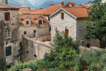 View of the Old Town with houses and red-tiled roofs and wooden shutters with a mountain in the background