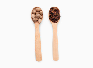 Wooden spoons with cloves and nutmeg on white