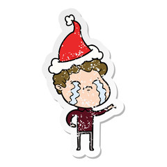 distressed sticker cartoon of a man crying wearing santa hat