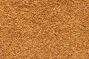 Golden texture of aromatic fenugreek seeds closeup