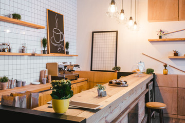 wooden brown bar counter with plants and cupcakes in coffee house