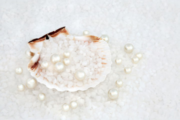 Oyster pearls with course sea salt in a scallop seashell forming a background. Has many health benefits due to the high number of trace minerals. Top view.
