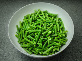Green beans in a white bowl top view.