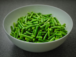 Green beans in a white bowl.