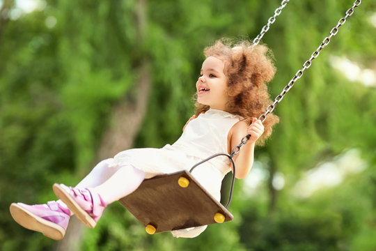 Child swinging on a swing at  playground in the park. 