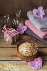 Obraz na płótnie Canvas Sea salt, natural handmade soap, natural cosmetic oil and colorful towels with azalea flowers on rustic wooden background