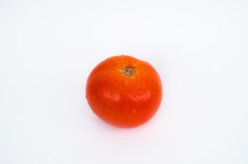Red tomato with water drops on a white background. Photo of food. Vegetable. Horizontal photo.
