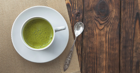cup of Matcha tee on wooden background