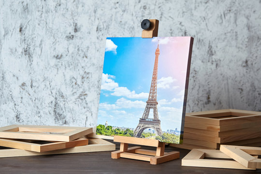 Canvas print: travel photography of Paris on a wooden easel and stretcher bars on table