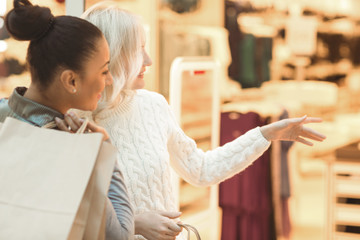 Cheerful mature female friends shopping together at the mall