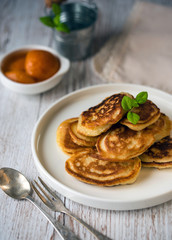 Shrove Tuesday, pancake day.  Pancakes poured with honey on the background of vintage plates, forks and knives. Shrovetide.