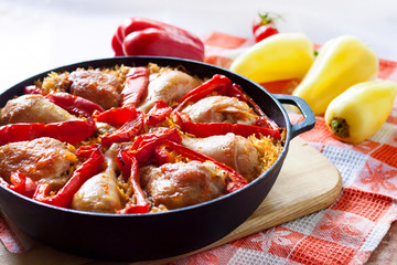 Chicken thighs and legs baked over a bed of rice and red bell pepper