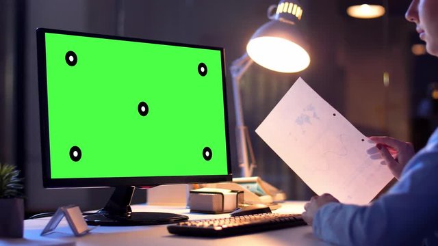 business, deadline and technology concept - businesswoman with chroma key green screen on computer monitor having video call at night office