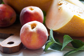 ripe peaches with sliced melon is close on the table
