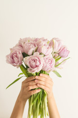 Beautiful big bouquet of double violet tulip flowers in hand on white background