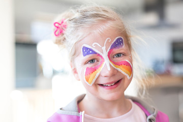 Portrait of blonde girl smiling with painted face