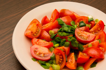 salad of small cherry tomatoes and green onions in a ceramic plate