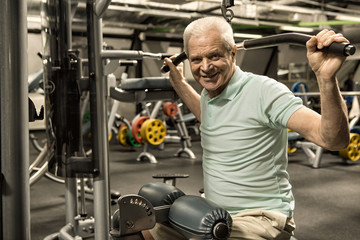 Fototapeta na wymiar Elderly man working out at the gym studio