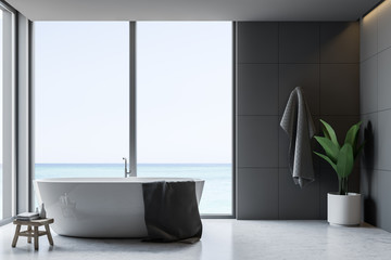 Gray tile bathroom interior, tub and towel