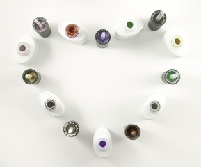 Bottles of nail Polish in the form of a heart on a white background. The view from the top.