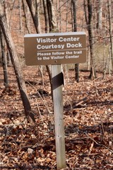 A brown park sign in the forest on a close view.