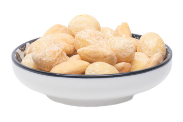 Nuts background. Close-up of roasted and salted macadamias and almonds nuts in ceramic bowl isolated on a white background. Gourmet nut mix with macadamias. Macro.