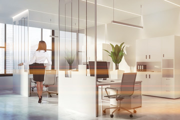 Woman in white and glass office with bookcases