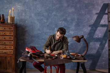 engineering design. young male designing shoes at te table