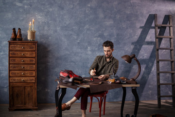 man drawing the sole of shoe. Boots and shoes manufacturing concept, full length photo