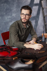 young beraded man taking an order in the shoe shop. close up photo. shoemaker receiving an order
