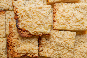 Freshly baked sand cake cut into pieces lie on top of each other