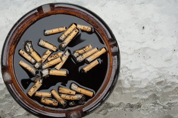 Cigarette butts in dirty ashtray